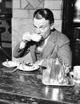 James Cagney stops at a restaurant in Grand Central Terminal where he enjoys some coffee and a danish, February 1945