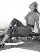 Pin-Up Betty Brosmer on a bench