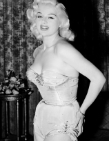 Diana Dors models a swimsuit she plans on wearing during the Cannes Film Festival, 1956